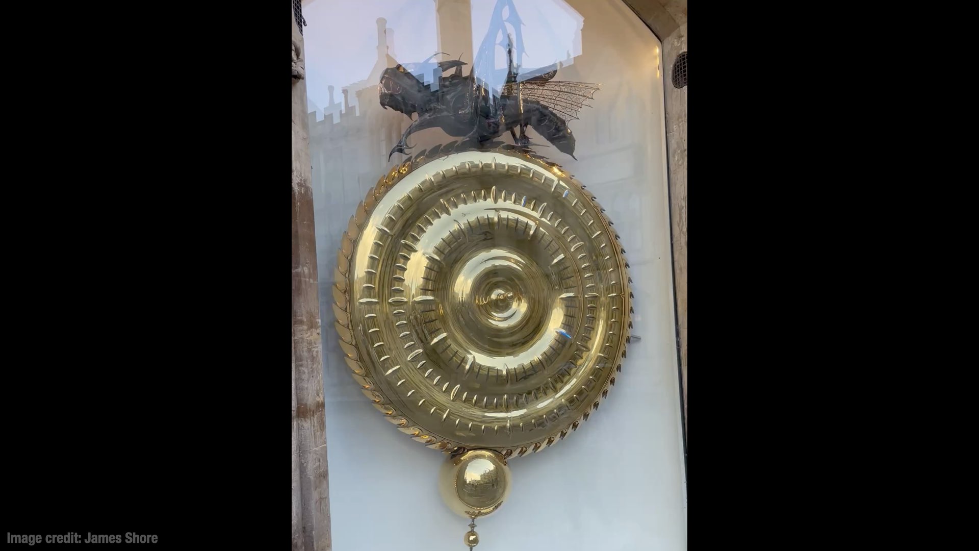 A picture of the Chronophage, a large circular clock with a grasshopper-like monster at the top.